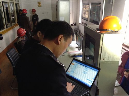 图为监察人员在将检查数据录入系统进行电子归档