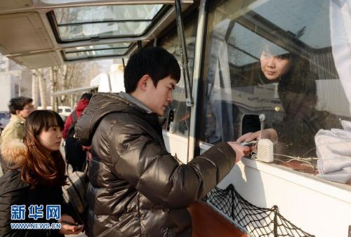 一名學(xué)生在北京郵電大學(xué)校園內(nèi)的流動(dòng)售票車(chē)窗口取票。 新華社記者 陳曄華 攝 