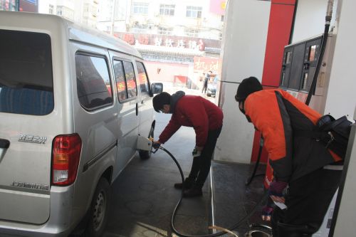 工作人員在給一輛汽車加油。