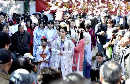 3月23日，表演者身著漢服在桃花樹下進行祭花活動。