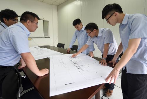 研發(fā)人員在娃哈哈集團(tuán)工業(yè)機(jī)器人工作站內(nèi)討論設(shè)計(jì)方案（5月8日攝）。