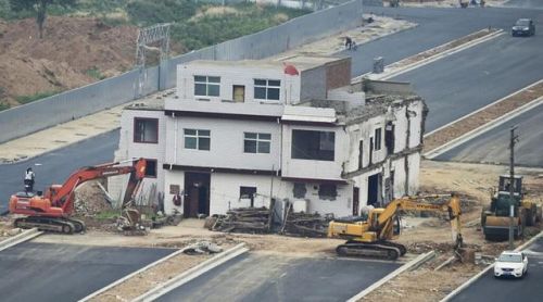 挖掘機推土機等待拆房。