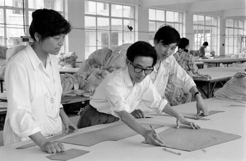 步鑫生在車(chē)間，與工人一起研究新產(chǎn)品的剪裁方案(4)