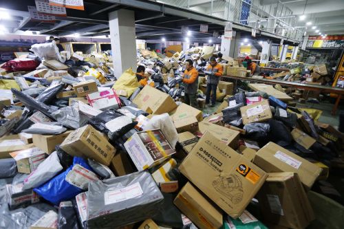 山東省濰坊市區(qū)一快遞公司分揀中心的工作人員在分揀包裹（2014年11月13日攝）。