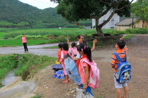 9月8日，在廣西武宣縣通挽鎮祿貴屯，覃曉靜（左一）護送學生回到村口后和學生道別。