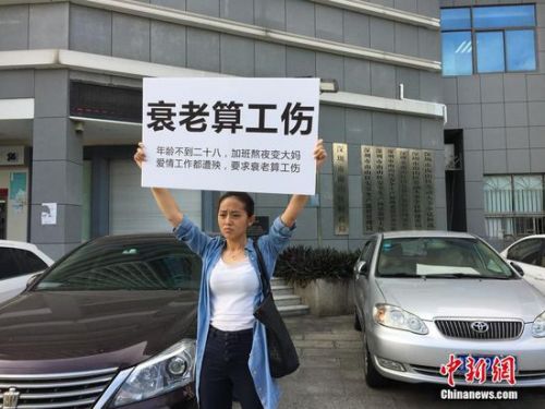 該名女白領(lǐng)在街頭舉著牌子抗議