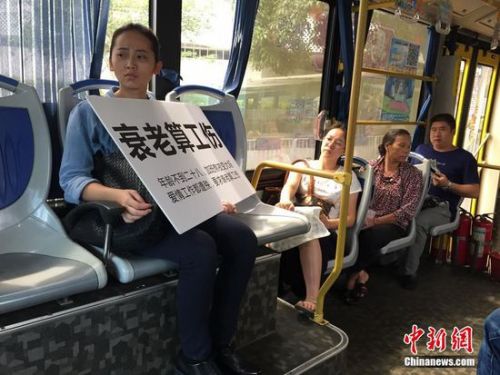 該名女白領(lǐng)在街頭舉著牌子抗議