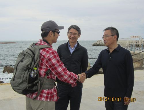 10月7日旅行官们在海洋牧场，旅游局李局长与旅行体验官陈子堃握手交谈