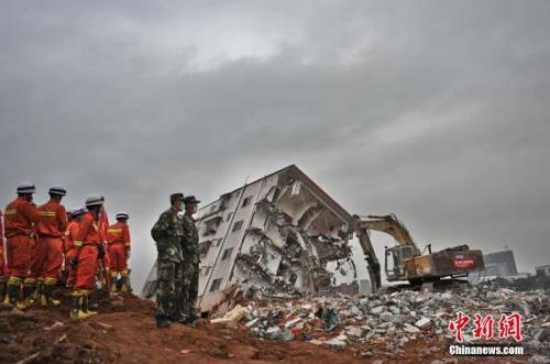 深圳山體滑坡 消防員乘挖掘機(jī)進(jìn)土坑救援。視覺(jué)中國(guó) 