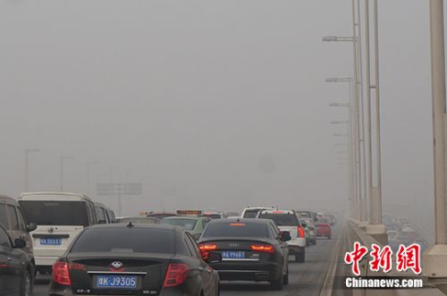 資料圖 霧霾籠罩著的鄭州高架橋，能見度低，車輛行駛緩慢。　周小云　攝