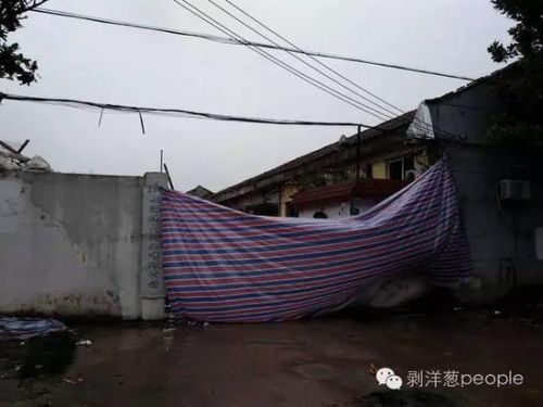 事發(fā)企業(yè)大門，事發(fā)后，有人用彩條布將大門遮住，其內一片狼藉。