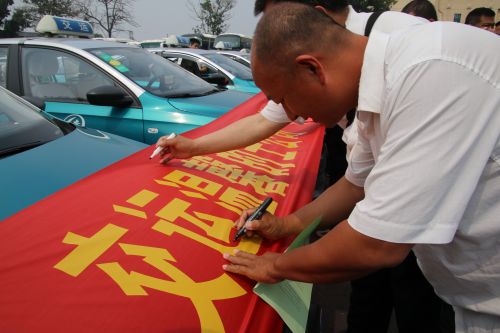 交運的士的哥的姐在“禮讓斑馬線”活動橫幅上簽名承諾