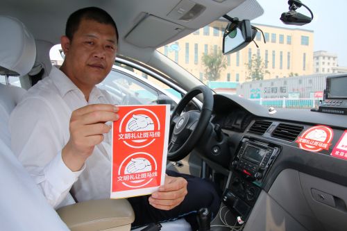 的哥展示“禮讓斑馬線”標識