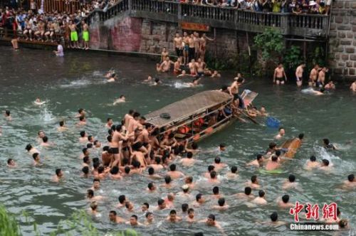 　5月30日，正值端午佳節(jié)，湖南鳳凰古城的沱江河上演搶鴨子大戰(zhàn)，眾多居民與游客紛紛跳入河中，爭搶從吊腳樓上拋下的鴨子，以此方式慶祝端午節(jié)的到來。 楊華峰 攝