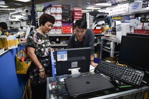 倪海真（左）到深圳華強北賽格電子市場五層的支部宣傳委員陳亞林柜臺前，與他溝通近期支部黨員學習的情況（2017年9月5日攝）。