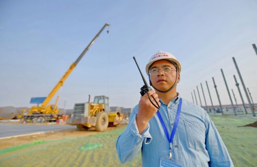 4月26日，來自中鐵上海工程局京雄城際鐵路五標二分部的工程師韓正順在京雄城際鐵路工程五標段小型構件預制廠場地建設現場用對講機指揮作業(yè)。