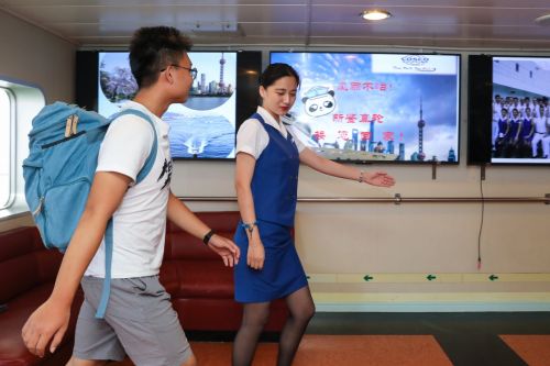 9月10日，在日本大阪&ldquo;新鑒真&rdquo;號渡輪上，工作人員（右）指引乘客辦理登船手續。