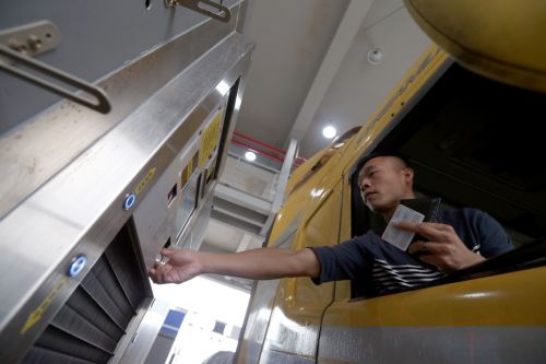 10月24日，港珠澳大橋珠海公路口岸通車的首票進口貨物貨車司機在抵達一站式貨車進境驗放通道時按指紋。