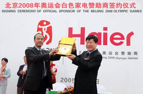 2005年,北京奧組委執行副主席王偉(前左)與海爾集團董事局主席兼首席執行官張瑞敏互贈禮品(資料照片)。