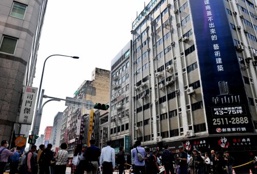 4月18日，媒體記者在臺北市長安東路二段受地震影響造成傾斜和裂縫的樓前進行現場報道。新華社記者 張國俊 攝