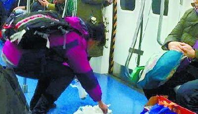 北京地鐵乘客暈車嘔吐 市民俯身擦凈嘔吐物(圖)